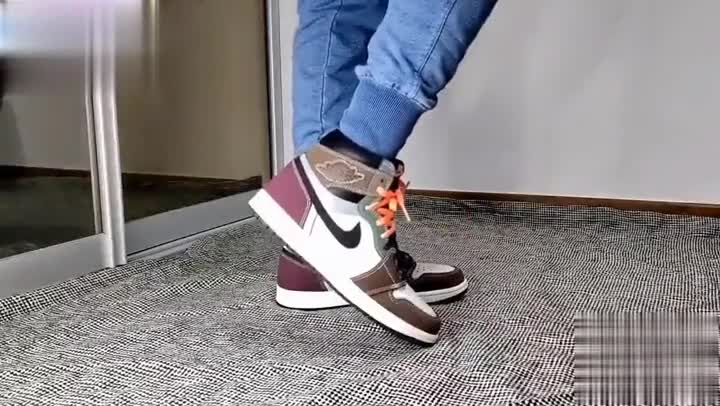 Air Jordan 1 Hand Crafted sneakers with contrasting brown and burgundy panels shown on foot